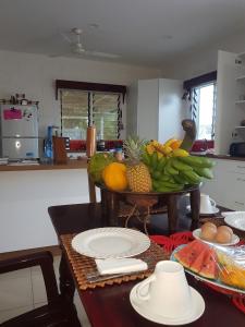 una cocina con una mesa con un montón de fruta. en Dayspring Lodge en Nukualofa