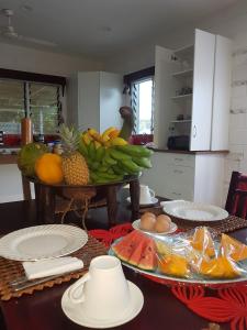 una cocina con una mesa con un montón de fruta. en Dayspring Lodge en Nukualofa