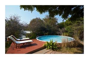 a bench sitting on a deck next to a swimming pool at Khem Villas in Sawāi Mādhopur
