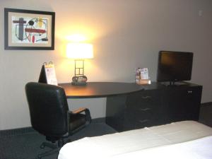 a desk in a hotel room with a lamp and a chair at Holiday Inn St. Paul Northeast - Lake Elmo, an IHG Hotel in Lake Elmo