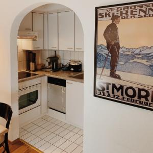 a kitchen with a picture of a man on the wall at Apartment Euforia in Samedan