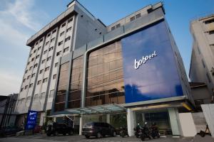 a jumeirah hotel with motorcycles parked in front of it at Bobotel Gatot Subroto Medan in Medan