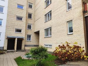 a large brick building with a yard in front of it at Nikoletos apartamentai in Panevėžys