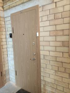 a wooden door in a brick wall at Nikoletos apartamentai in Panevėžys