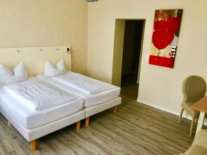 ein Schlafzimmer mit einem weißen Bett in einem Zimmer in der Unterkunft Pension am Pollingpark Haus II in Dessau