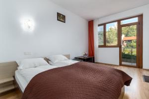 - une chambre avec un grand lit et une grande fenêtre dans l'établissement Vila Izvor, à Băile Felix