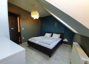 1 dormitorio con 1 cama con pared azul en INTRO Apartman en Sárvár