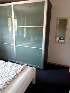 a bedroom with a glass wall with a bed at Moderne Ferienwohnung im Herzen von Schleswig in Schleswig