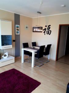 a dining room with a white table and black chairs at Moderne Ferienwohnung im Herzen von Schleswig in Schleswig