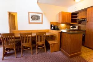 a kitchen with a table and chairs and a counter at Huge Superior 4 Bedroom Apartment, Arc 1950, Les Arc, Spaciously Sleeps 8 to 10 over two floors, Ski In Ski Out in Arc 1950