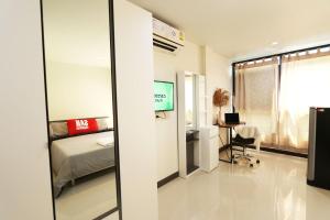 a bedroom with a bed and a desk and a window at Baanrao Bangson in Bangkok