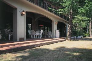 ein Gebäude mit Stühlen und Tischen und einem Baum in der Unterkunft The Gran Resort Elegante Karuizawa in Karuizawa