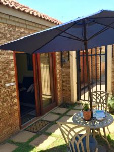 a blue umbrella over a table and a chair at 642 on Vincent in Pretoria