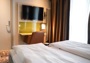 Habitación de hotel con cama y TV en la pared en Comfort Hotel Grand Central, en Oslo