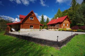 uma casa de madeira com um telhado vermelho e um quintal em PEGAZOWA WOLA CISNA em Cisna