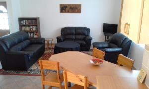 a living room with a couch and a table and chairs at Maggie´s Accommodation in Swakopmund