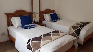 two beds in a hotel room with blue and white at Maggie´s Accommodation in Swakopmund