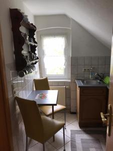 eine Küche mit einem Tisch, Stühlen und einem Waschbecken in der Unterkunft Ferienwohnung Familie Müller in Zwickau