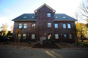 a brick house with a bike in front of it at Ferienhaus Zur Alten Maar, 65332 in Moormerland