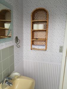 a bathroom with a sink and a shelf with towels at Havehøjegaard in Borre