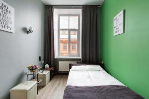 a green bedroom with a bed and a window at Nomera na Sadovoy in Saint Petersburg
