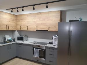 a kitchen with wooden cabinets and a stainless steel refrigerator at VILLA 17 Noclegi in Płock