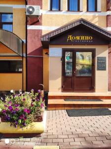 a restaurant with flowers in front of a building at Domino Hotel in Nizhny Novgorod