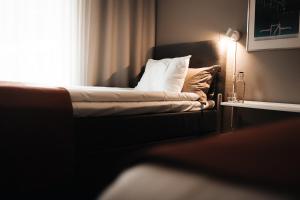 1 cama y 1 sofá en una habitación con ventana en Ädelfors Hotell & Vandrarhem, en Holsbybrunn