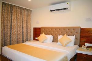 a bedroom with a large bed with white sheets and pillows at Hotel Milan International in Mumbai