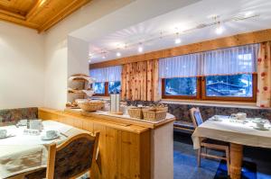 a dining room with two tables and two windows at Hotel Garni Golfais in Ischgl