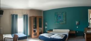 1 dormitorio con 2 camas y pared azul en Logis Hotel Le Clos Des Oliviers, en Bourg-Saint-Andéol