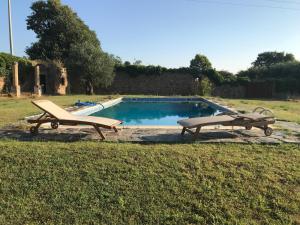 - une piscine avec 2 chaises longues à côté dans l'établissement La Caseta del Mas Valls, à Rupiá