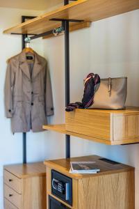 a closet with wooden shelves and a jacket and a purse at Maison Montechiaro in Vico Equense