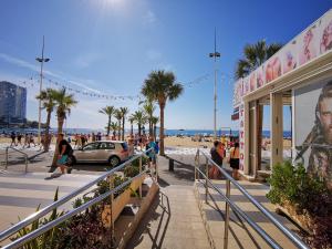 een groep mensen die op een stoep bij het strand lopen bij Gestión Inmobiliaria Carmona Rent in Benidorm
