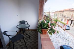 einen Balkon mit 2 Stühlen, einem Tisch und Blumen in der Unterkunft Relax da Carmen in Vatolla