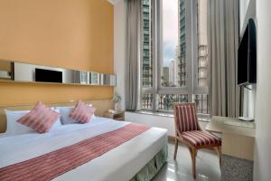 a hotel room with a bed and a desk and window at Rambler Garden Hotel in Hong Kong