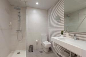 a bathroom with a toilet and a sink and a shower at Spirit Hotel Ciudad de Burgos in Rubena