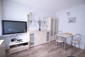 グディニャにある01 Gdynia Centrum - Apartament Mieszkanie dla 2 osのリビングルーム(テレビ、テーブル、椅子付)