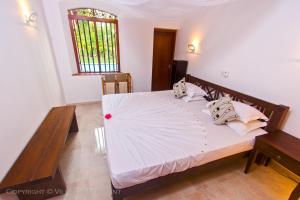 a bedroom with a large bed with an umbrella on it at Villa Cookie Aunt in Bentota