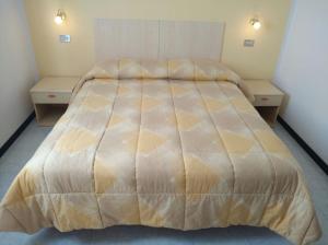 a bedroom with a large bed with two tables at Appartamenti Fiordaliso in Sirmione