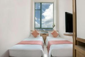 A bed or beds in a room at Rambler Garden Hotel