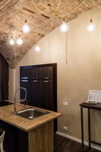 a kitchen with a sink and a ceiling with lights at la casa del vicolo - city center - in Perugia