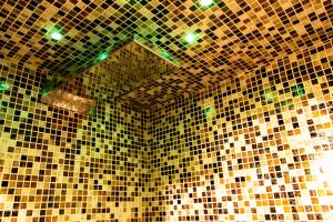 a bathroom with brown and green tiled walls at la casa del vicolo - city center - in Perugia