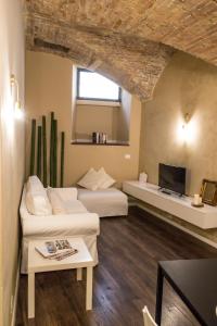 a living room with two beds and a tv at la casa del vicolo - city center - in Perugia