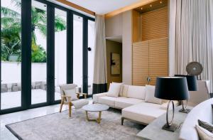 a living room with a white couch and a large window at Capella Tufu Bay, Hainan in Sanya