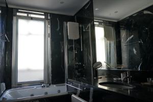 a black bathroom with a sink and a window at Room 56 - Le Dimore in Bari