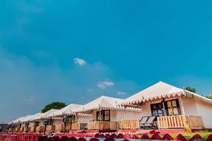 eine Reihe weißer Zelte vor einem Gebäude in der Unterkunft Rawai Luxury Tents Pushkar in Pushkar