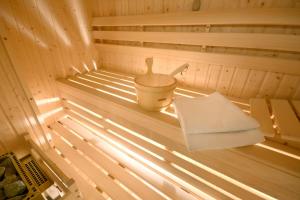 a sauna with a bucket and a towel in it at Hotel Rubinstein in Krakow