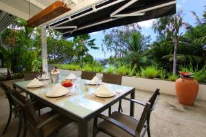 a table on a patio with a view of the ocean at Hillcrest Villas in Glacis