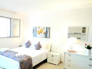 a white bedroom with two beds and a dresser at Residence Maresol in Vieste